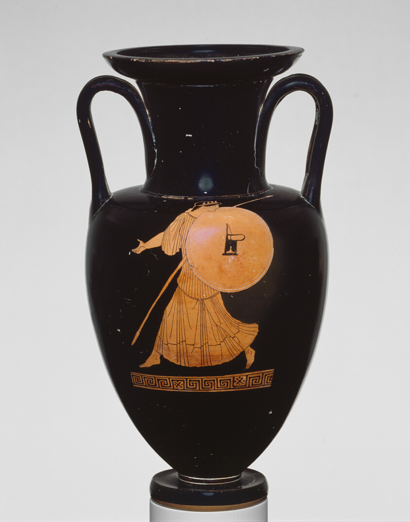 Terracotta vessel glazed in black, decorated with an orange figure of a woman holding a shield and a spear.