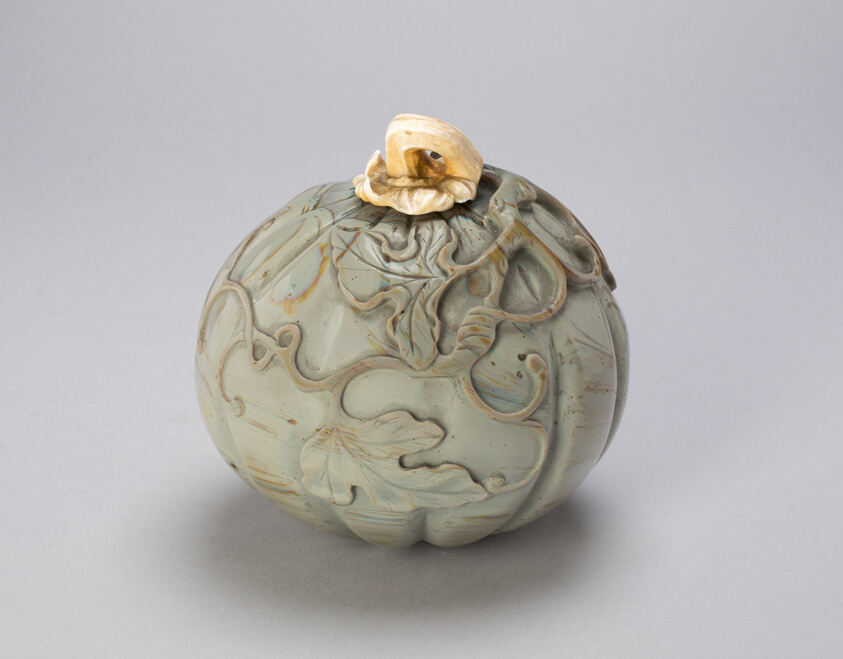 A work made of gray opaque glass with ivory lid.