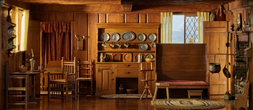 Miniature of a cozy living room and kitchen in rich maple-colored wood tones, hardwood floors and wood paneling on the walls, a large brick fireplace and stove on the right. A cupboard on the back wall contains silver plates and mugs.