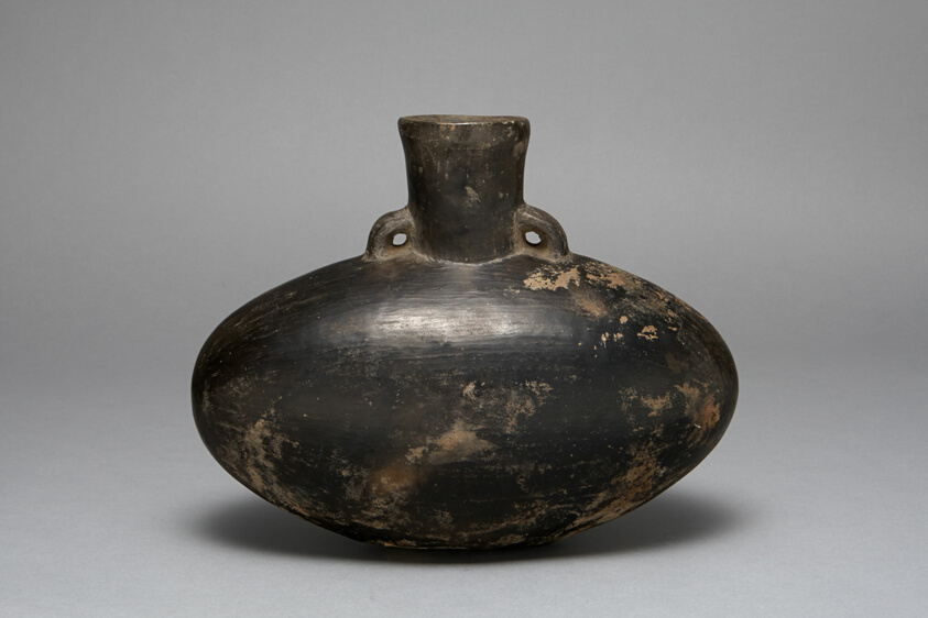 A squat oval-shaped ceramic jar, painted black, with a cylindrical top and two very small handles on either side of the top. Some visible paint loss.